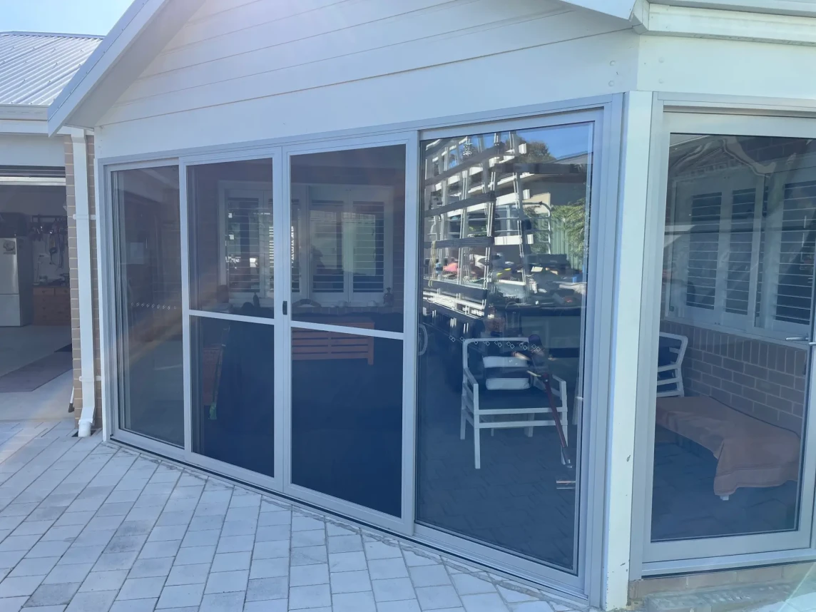 Open bi fold door to a living and dining area of a residential home.